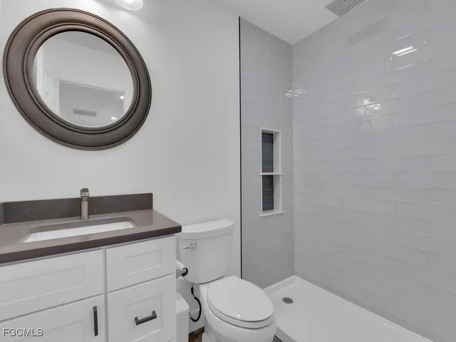 a bathroom with a toilet a sink and a mirror