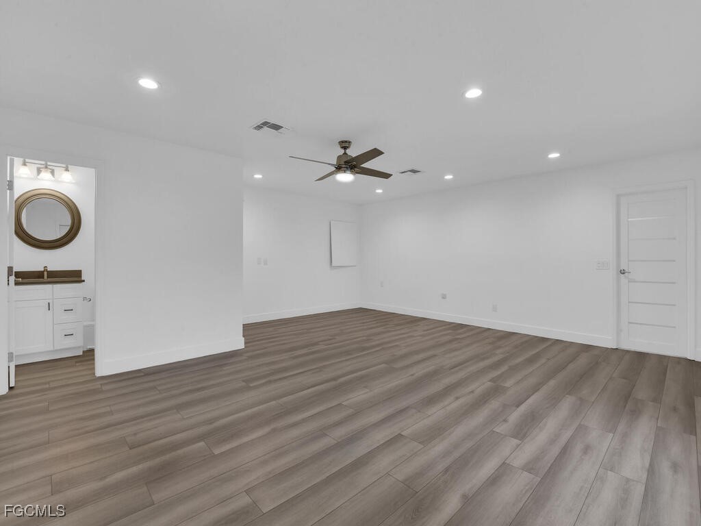 11981 Plantation Road Fort Myers, FL 33966 - Photo 25 of 48 an empty room with wooden floor and windows