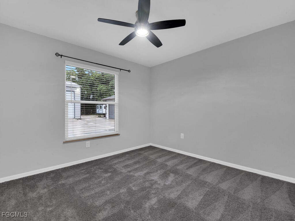 11981 Plantation Road Fort Myers, FL 33966 - Photo 26 of 48 an empty room with a window and a ceiling fan