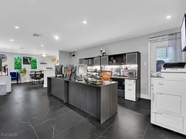 a kitchen with stainless steel appliances kitchen island granite countertop a refrigerator a stove top oven a sink dishwasher and white cabinets with wooden floor