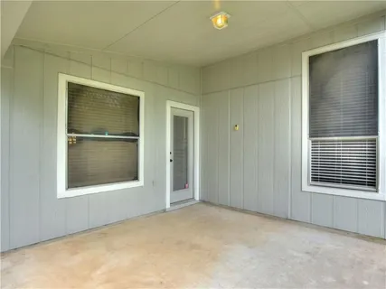 an empty room with a window and a kitchen
