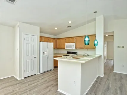 a view of kitchen with stainless steel appliances granite countertop a stove and a refrigerator