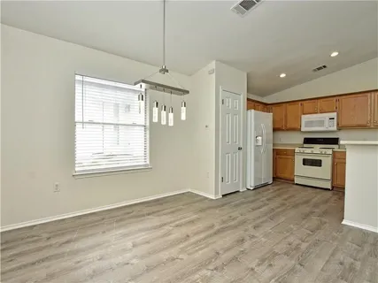 a view of a kitchen with a sink a refrigerator and window