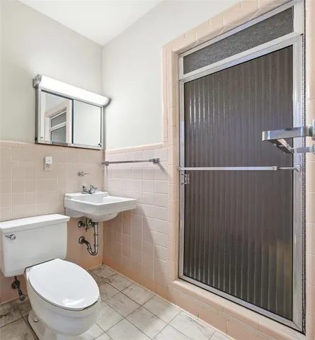 a bathroom with a toilet a sink and mirror