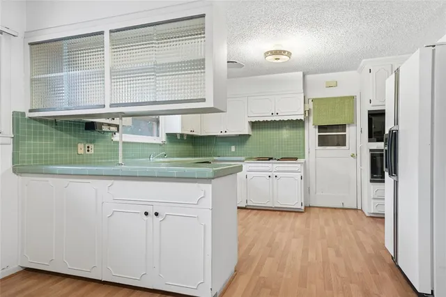 a kitchen with a sink a refrigerator and window