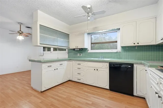 a kitchen with granite countertop white cabinets and white appliances