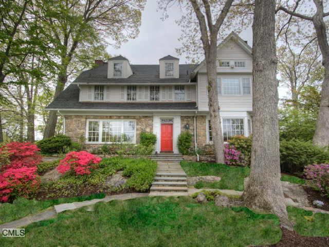 a front view of a house with yard and green space