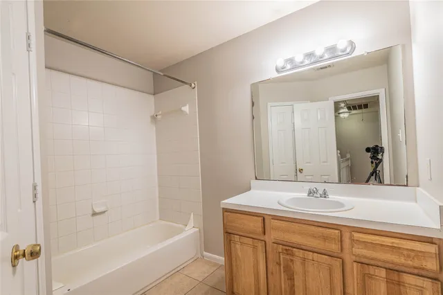a bathroom with a bathtub shower sink vanity and mirror