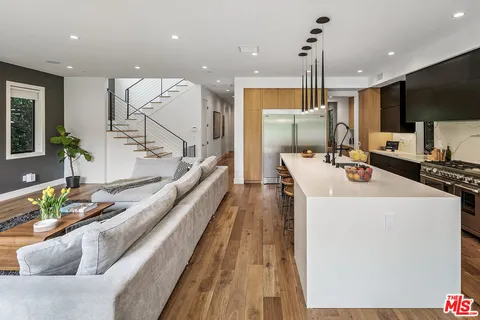 a kitchen with stainless steel appliances kitchen island granite countertop a sink and a refrigerator