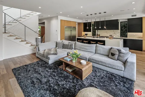 a living room with furniture and kitchen view