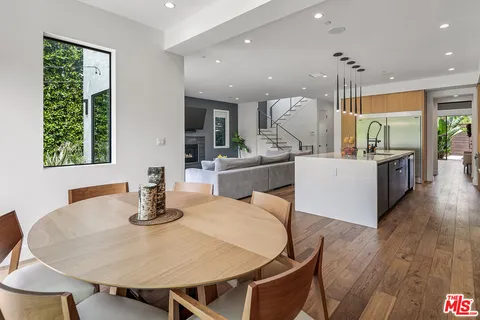 a kitchen with a table chairs and wooden floor