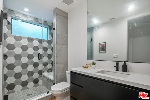 a bathroom with a double vanity sink toilet and shower