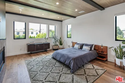 a spacious bedroom with a bed and wooden floor