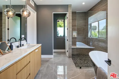 a bathroom with double vanity and a mirror