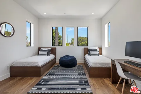 a bedroom with a bed couches chair and a large window