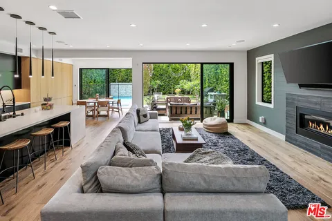 a living room with furniture fireplace and a large window