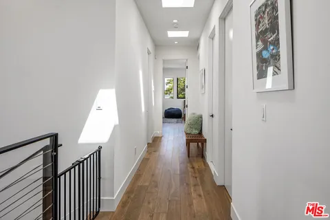 a view of a hallway with wooden floor and staircase