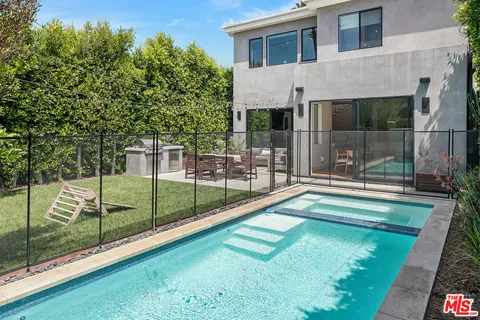 a view of a backyard with swimming pool