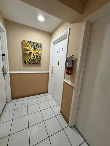 a view of a storage & utility room with fridge and wooden floor
