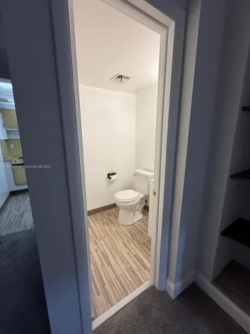 a bathroom with a granite countertop toilet and a sink