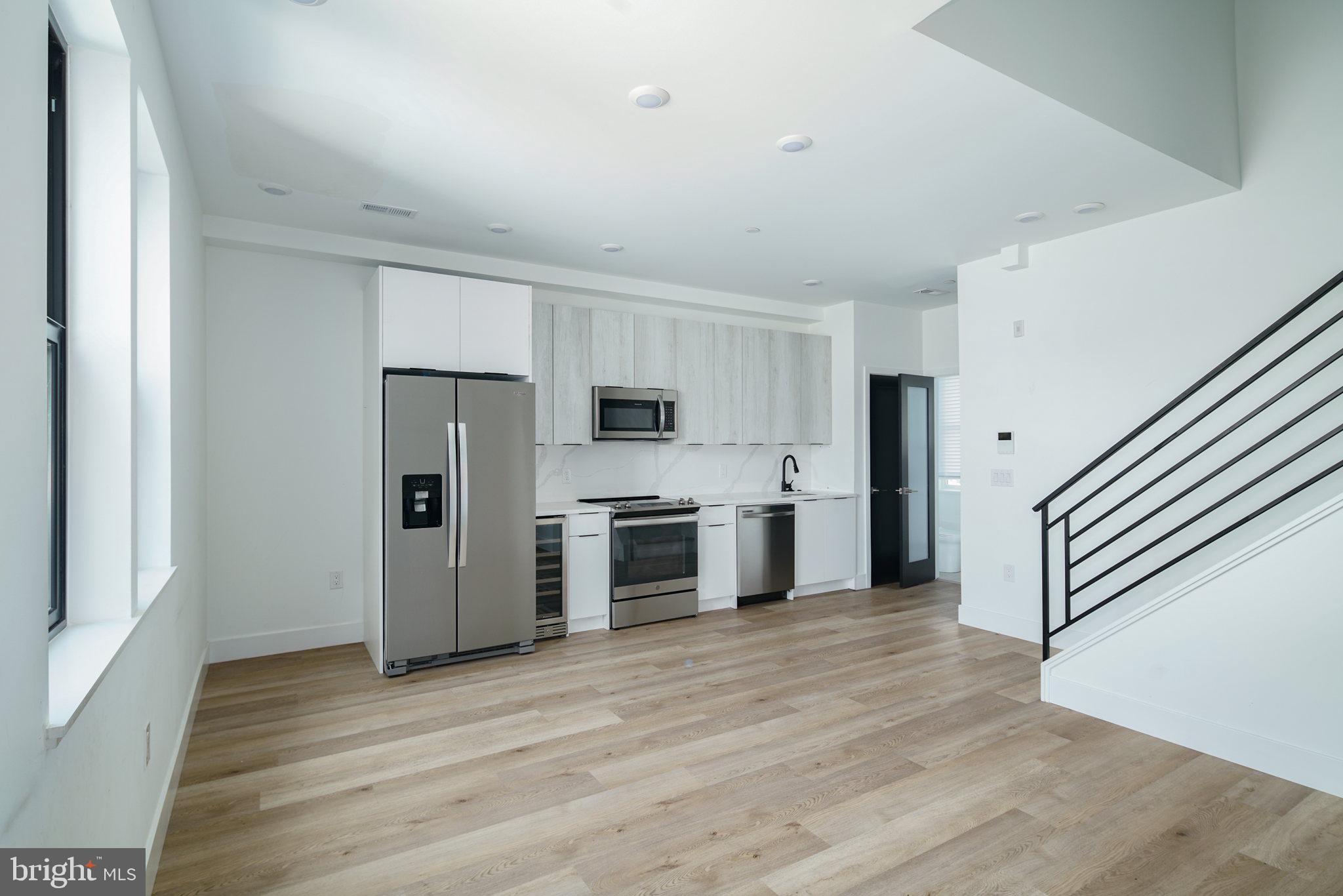 a kitchen with stainless steel appliances a refrigerator and a stove top oven