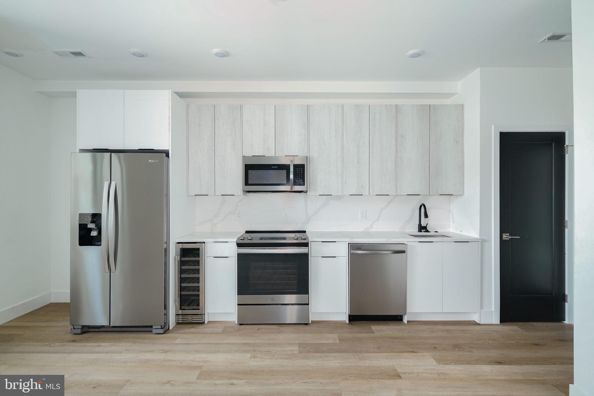 930 North 2nd Street, Unit 3 Philadelphia, PA 19123 - Photo 3 of 20 a kitchen with stainless steel appliances and wooden cabinets