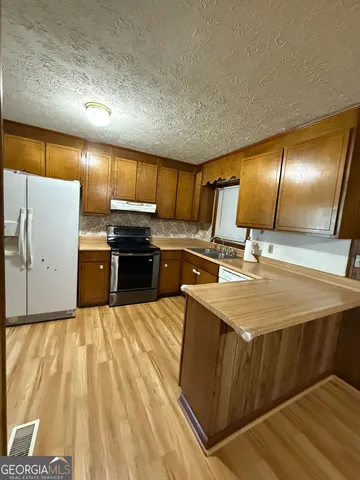 a kitchen with kitchen island a counter top space cabinets and stainless steel appliances
