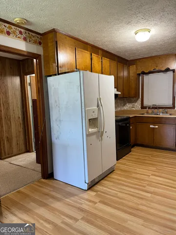 a kitchen with stainless steel appliances granite countertop a refrigerator and a sink