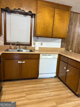a view of a kitchen with wooden floor and a sink