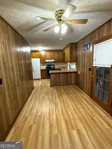 a large kitchen with stainless steel appliances a large counter top a stove and a refrigerator