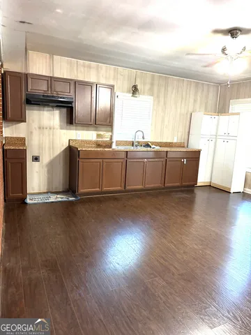 a kitchen with stainless steel appliances wooden floors and white cabinets