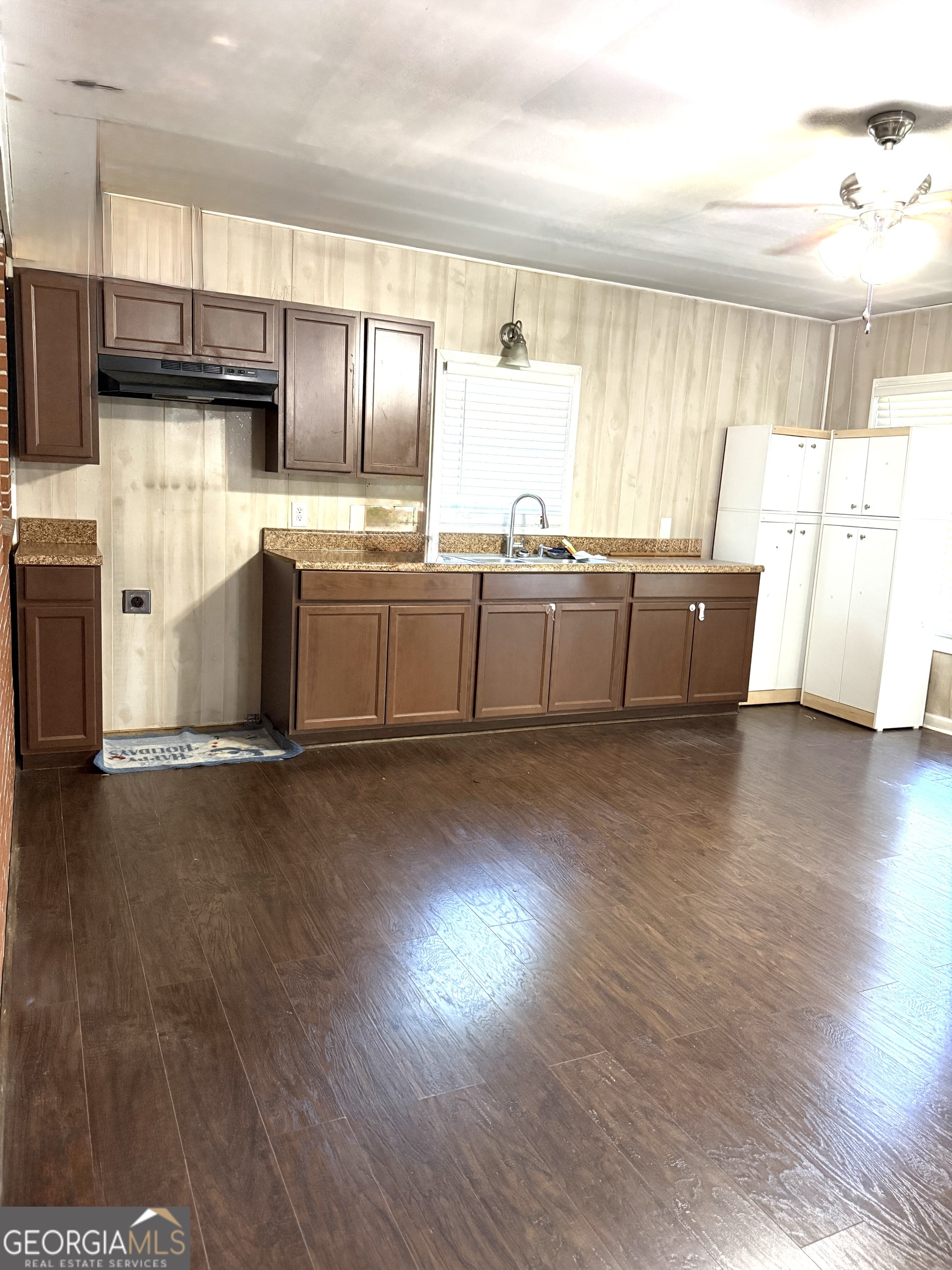 140 Rene Lane Cochran, GA 31014 - Photo 22 of 29 a kitchen with stainless steel appliances wooden floors and white cabinets