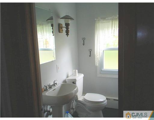 935 New Dover Road Edison, NJ 08820 - Photo 4 of 9 a bathroom with a sink toilet and a mirror