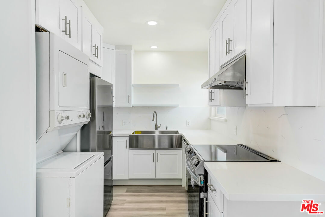 1255 26th Street, Unit 1 Santa Monica, CA 90404 - Photo 5 of 10 a kitchen with stainless steel appliances a refrigerator a stove and white cabinets