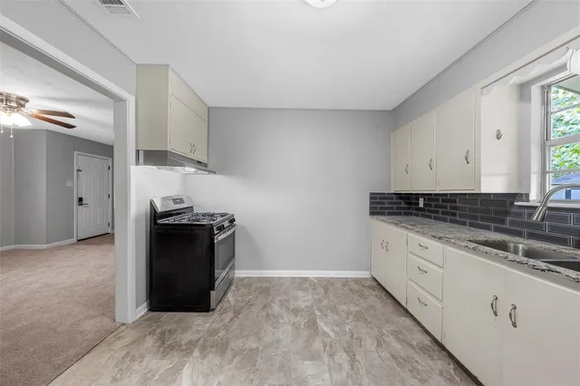 a kitchen with granite countertop a refrigerator and a stove