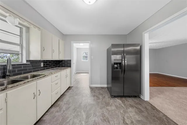 a kitchen with granite countertop a refrigerator and a sink