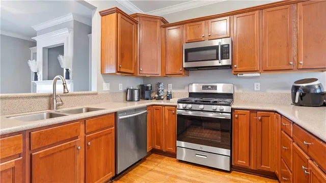a kitchen with stainless steel appliances granite countertop wooden cabinets a stove and a sink