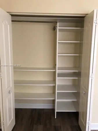 a view of walk in closet with empty racks