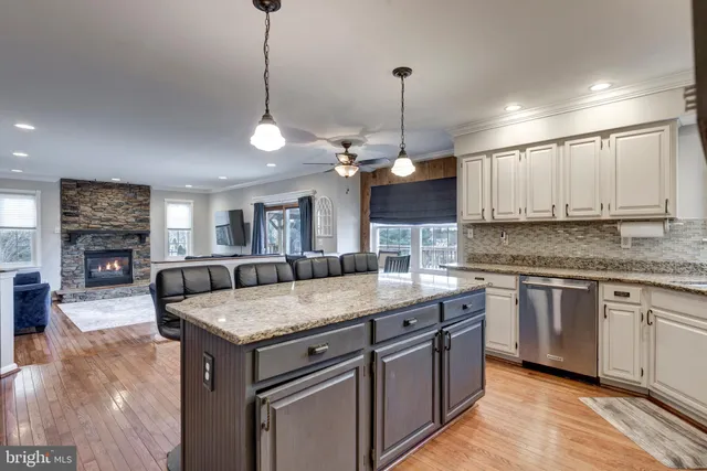 a kitchen with stainless steel appliances granite countertop a sink a stove top oven a counter space and cabinets