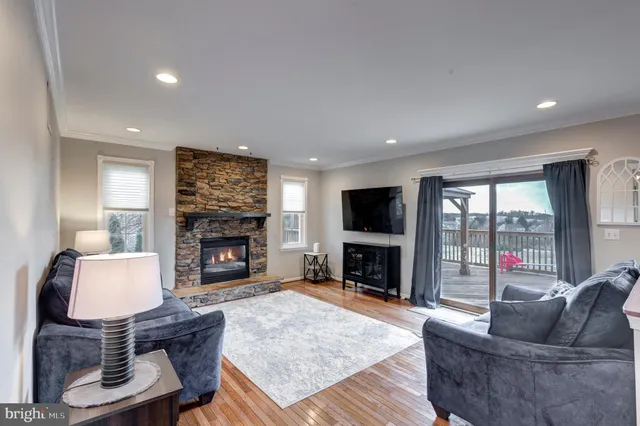 a living room with furniture a fireplace a flat screen tv and a large window