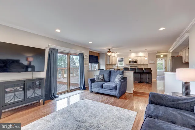 a living room with furniture and a view of kitchen