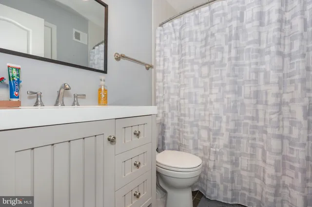 a bathroom with a sink a toilet and a mirror