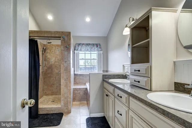 a bathroom with a granite countertop sink a mirror and a shower