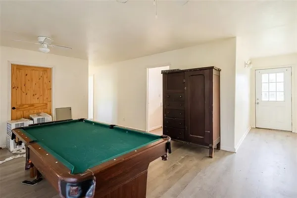 a room with pool table and windows