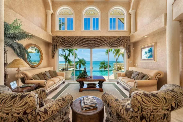 a kitchen with stainless steel appliances kitchen island granite countertop a stove a refrigerator and a dining table with white cabinets