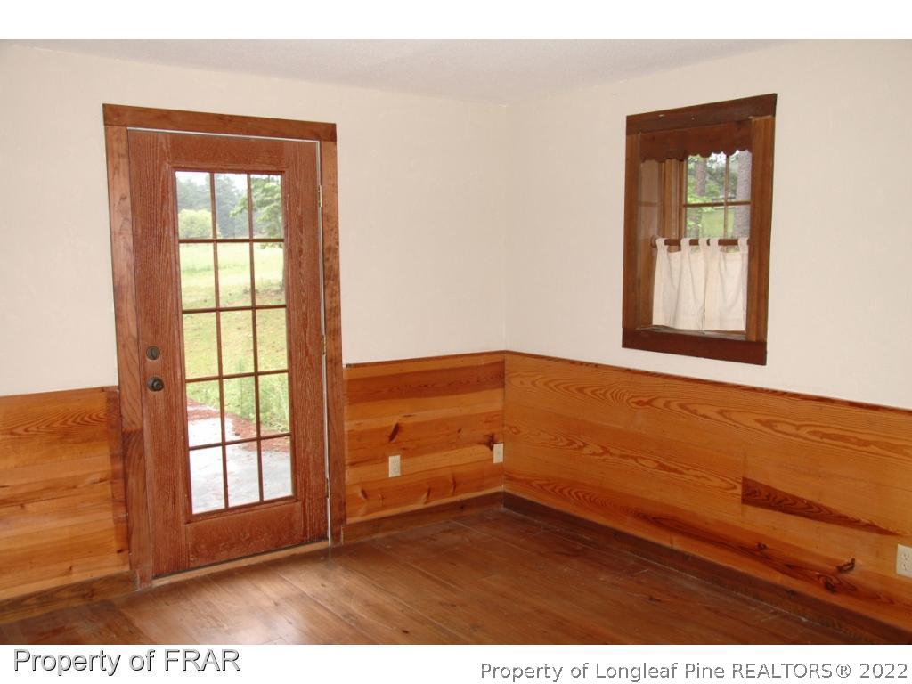 4949 Niagara Carthage Road Southern Pines, NC 28387 - Photo 9 of 18 an empty room with wooden floor and windows