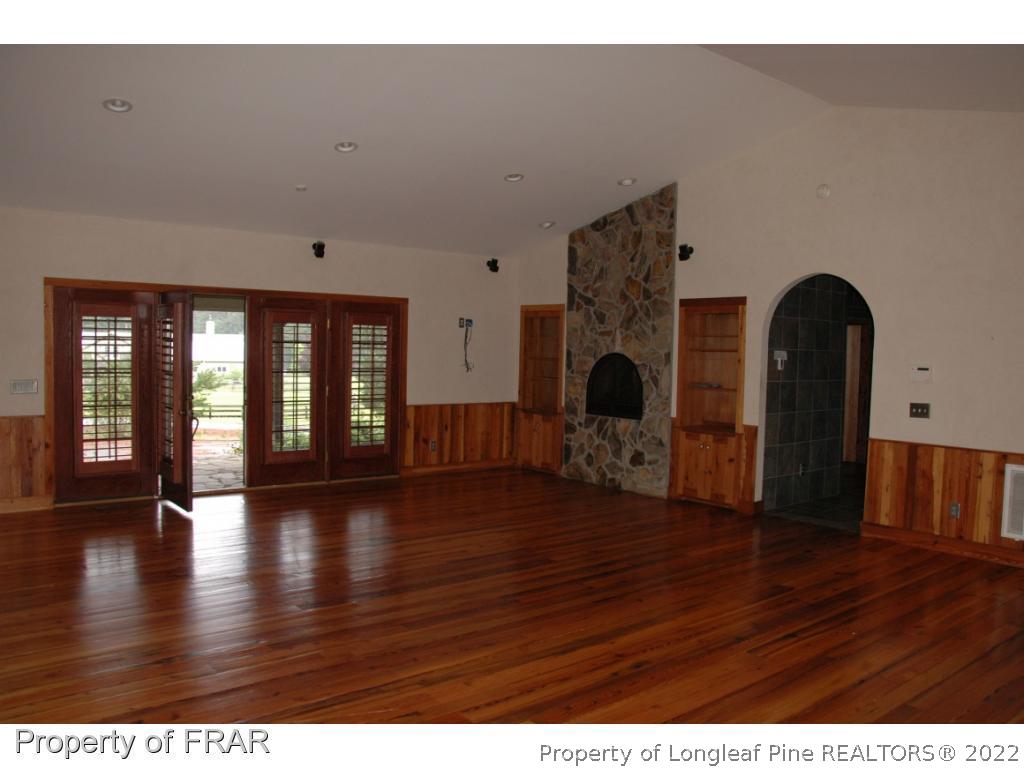 4949 Niagara Carthage Road Southern Pines, NC 28387 - Photo 10 of 18 a view of an empty room with wooden floor and a fireplace