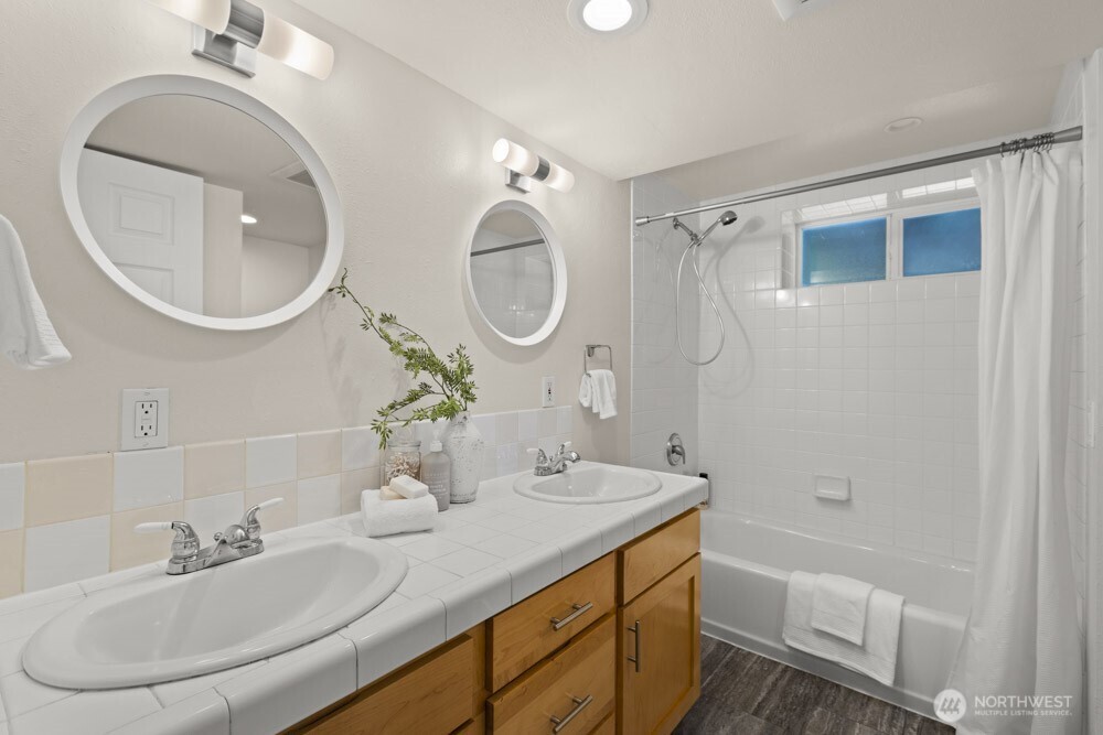4146 47th Avenue Southwest Seattle, WA 98116 - Photo 29 of 40 a bathroom with a granite countertop sink a mirror and a shower