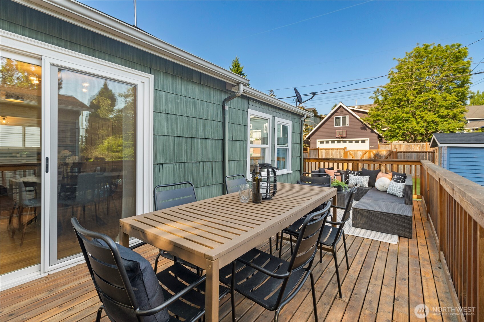 4146 47th Avenue Southwest Seattle, WA 98116 - Photo 30 of 40 a view of a patio with table and chairs with wooden floor and fence
