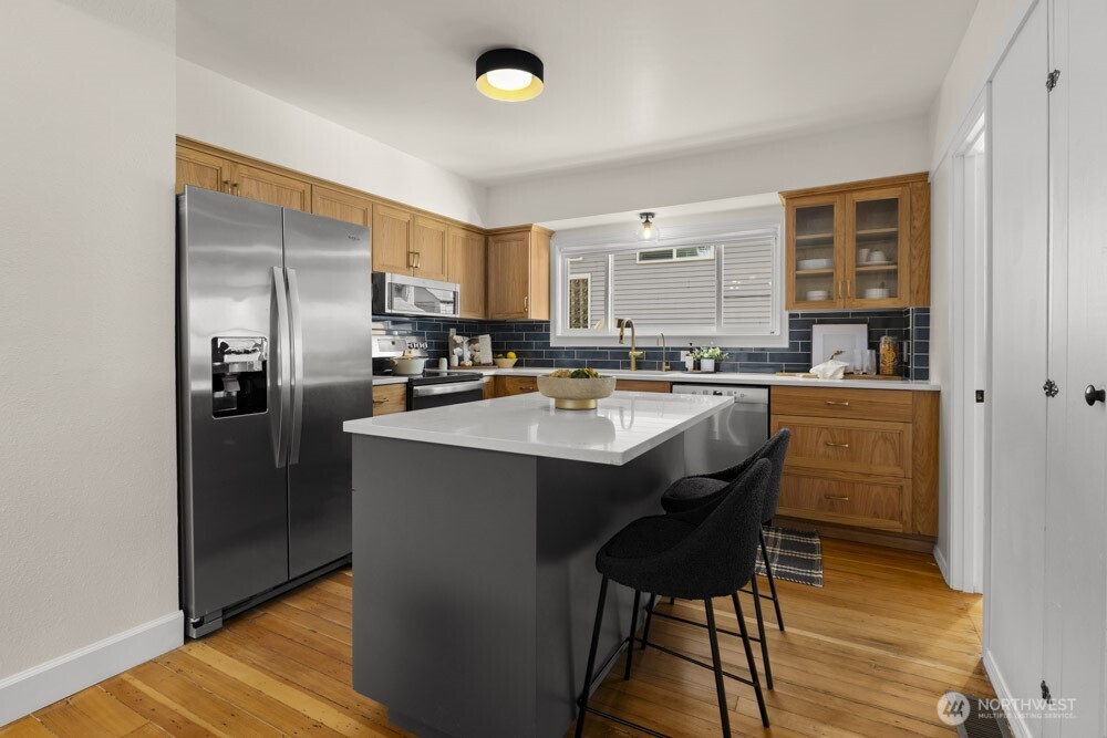 4146 47th Avenue Southwest Seattle, WA 98116 - Photo 10 of 40 a kitchen with stainless steel appliances a sink stove and refrigerator